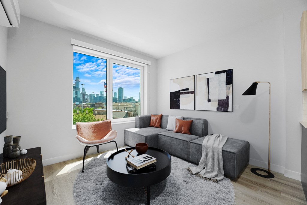 a living room with a gray couch and a large window at Inspire West Town, CHICAGO, 60642
