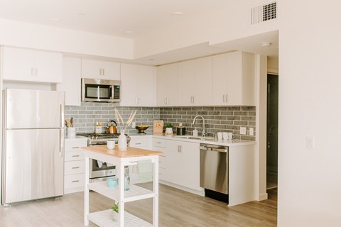 a kitchen with white cabinets and stainless steel appliances