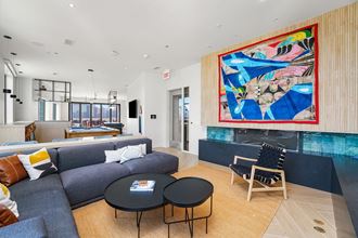 a living room with a large painting on the wall and a couch and chairs in front of at Inspire West Town in Chicago, IL