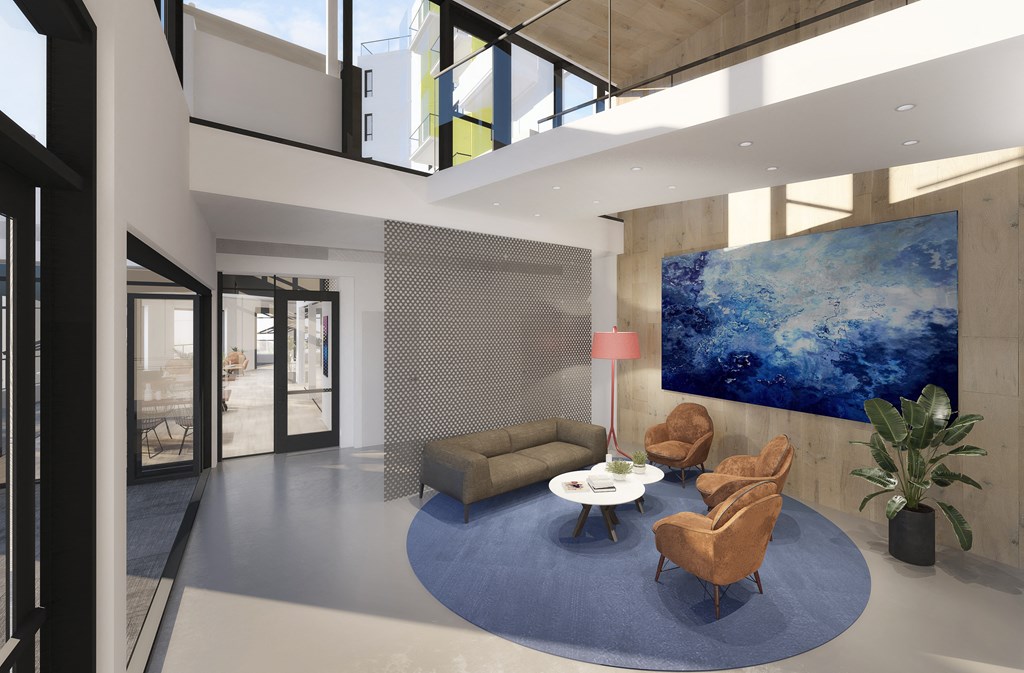 a living room with a blue rug and a couch and chairs