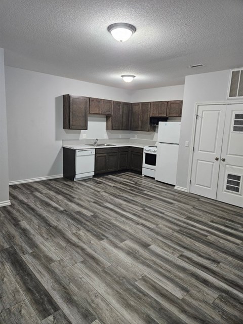 A kitchen with white appliances and wooden cabinets.