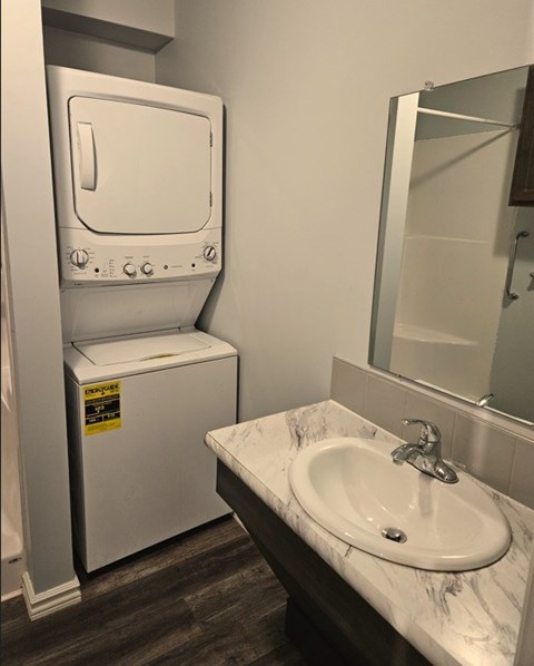 A bathroom with a toilet, sink, and mirror.