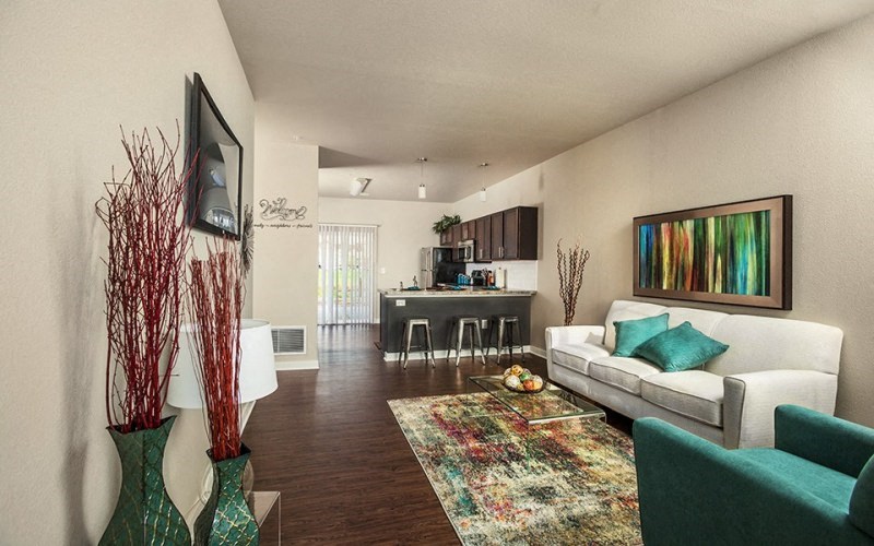 a living room with a couch and a chair and a kitchen