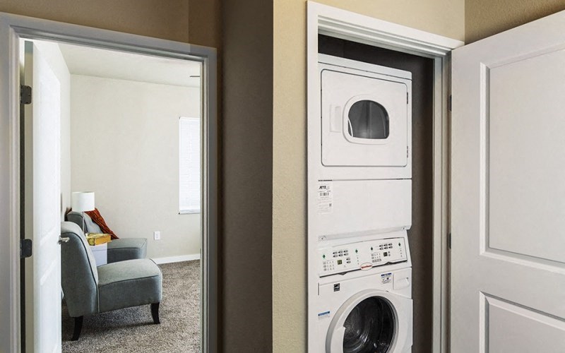 a view of a washer and dryer in a living room with a door