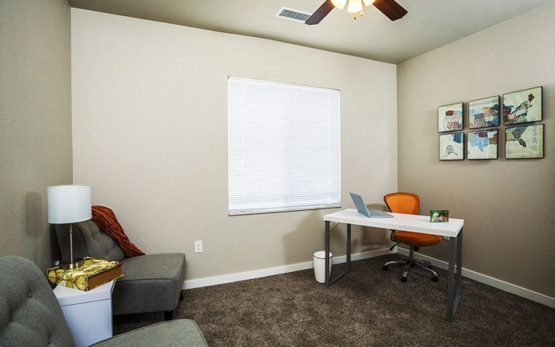 a home office with a desk and chair and a window