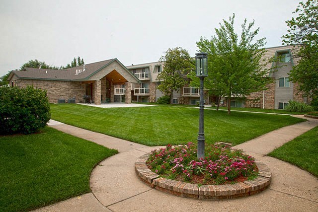 a street sign in the middle of a flower garden