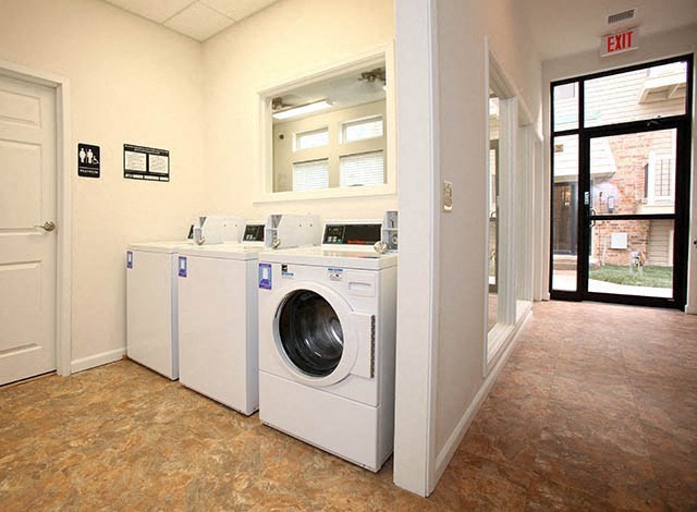 a laundry room with four washing machines in it