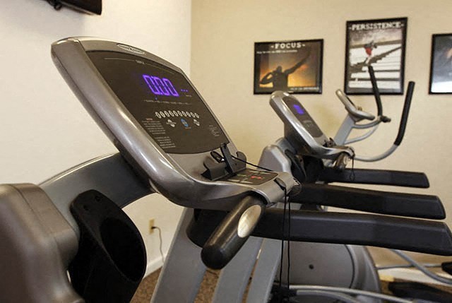 a treadmill in a gym with some exercise equipment