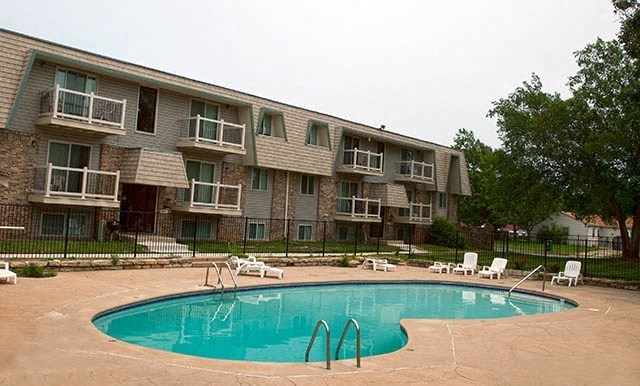 a large swimming pool in front of an apartment building