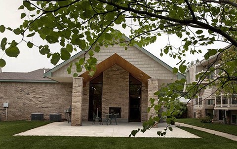 a brick building with a patio and a tree