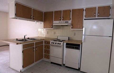 a kitchen with white appliances and wooden cabinets