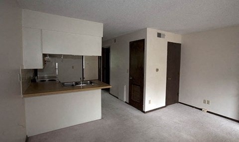 an empty kitchen with white cabinets and a sink
