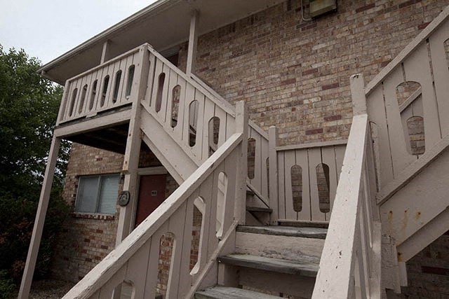 an old brick building with stairs and a balcony