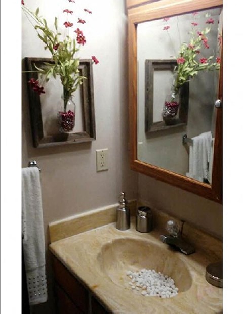 a bathroom with a sink and a mirror with flowers in it
