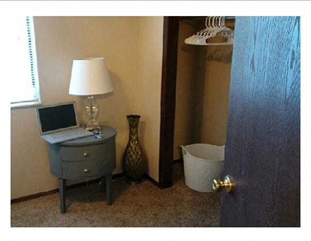 a bathroom with a laptop on a night stand next to a closet