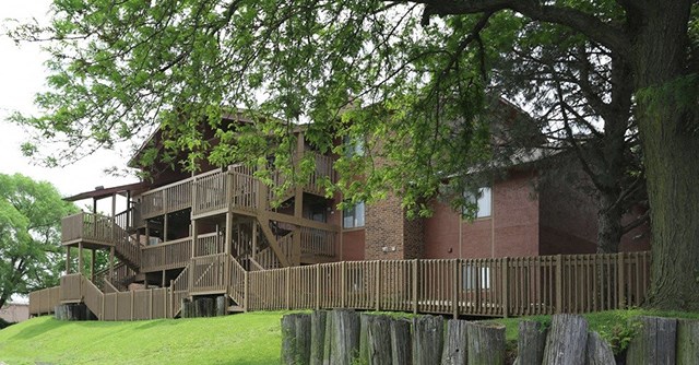 an image of a house with a deck and a tree