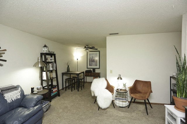 a living room with a couch and chairs and a dining room table