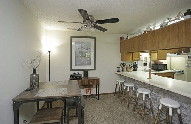 an open kitchen and dining room with a long counter and a bar with stools