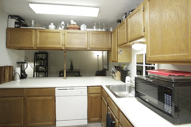 a kitchen with wooden cabinets and a white counter top