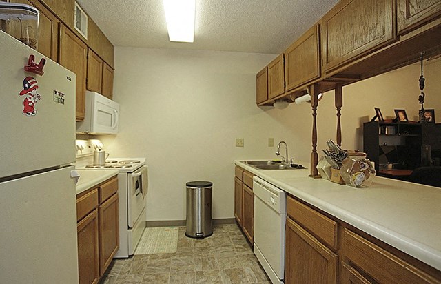 a kitchen with white appliances and wooden cabinets