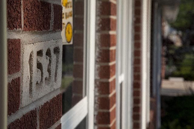 a brick wall with a window and a sign on it
