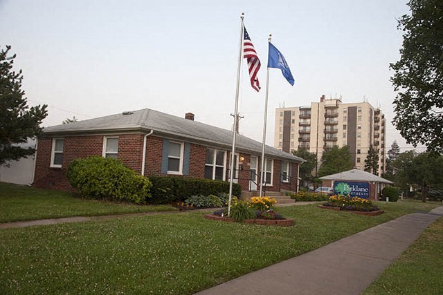 a small brick house with two flags in front of it