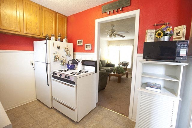 a kitchen with a stove refrigerator and a microwave