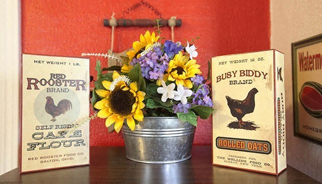 a metal bucket with flowers and books on a table