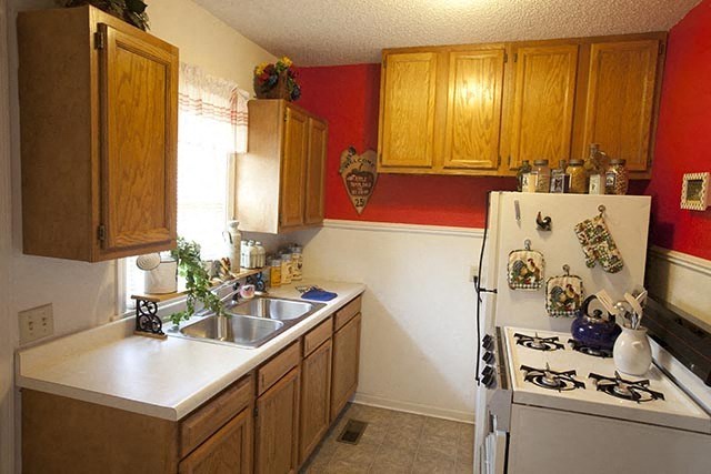 a kitchen with a stove a sink and a refrigerator