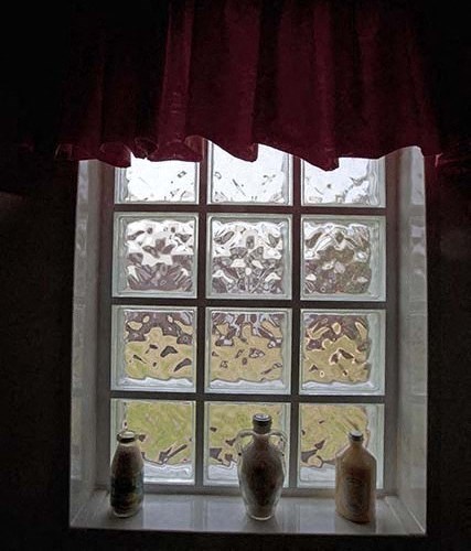 a window with four vases sitting on a window sill
