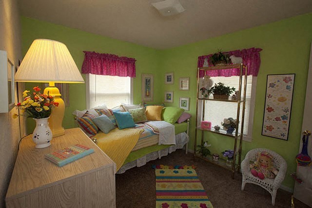 a bedroom with a bed and a table and a lamp