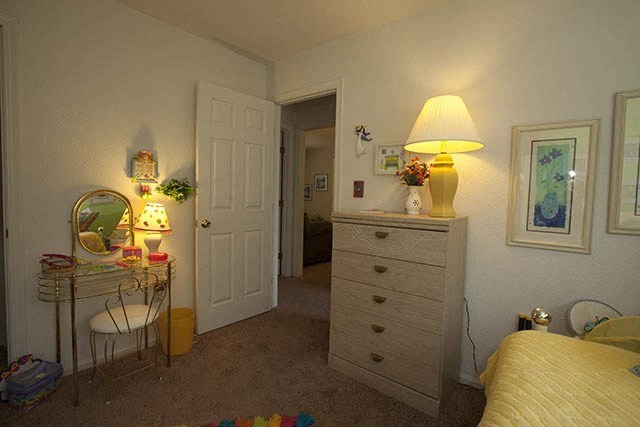 a bedroom with a bed and a table with a lamp