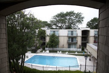 the view of a swimming pool in front of an apartment building