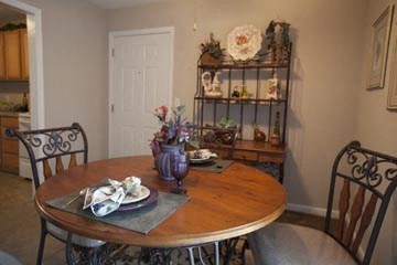 a dining room with a wooden table and chairs