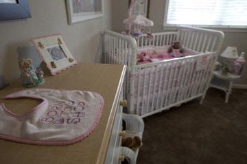 a baby room with two cribs and a table and a desk