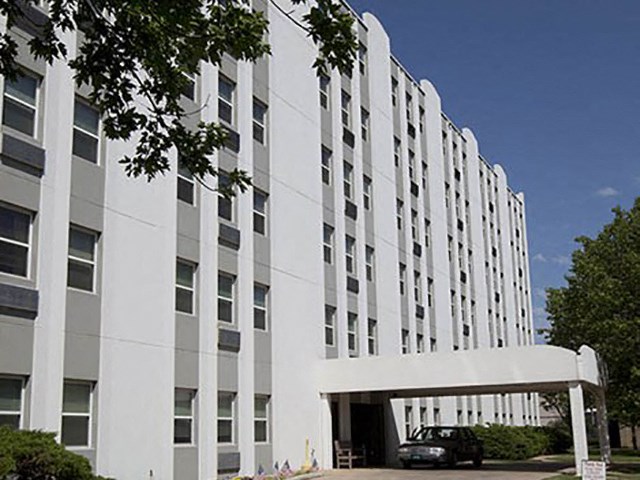 a large white building with a car parked in front of it