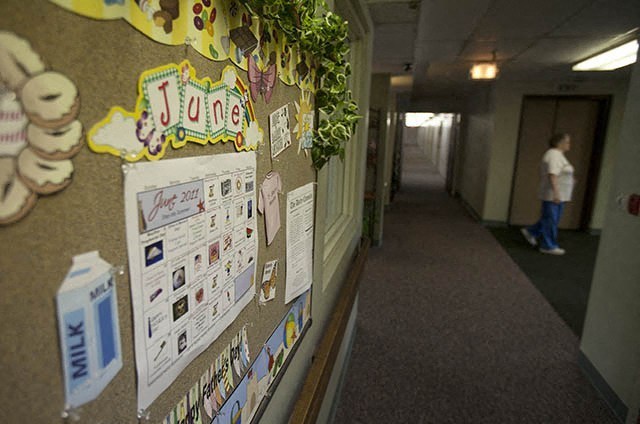 a hallway in a building with a bulletin board on the wall