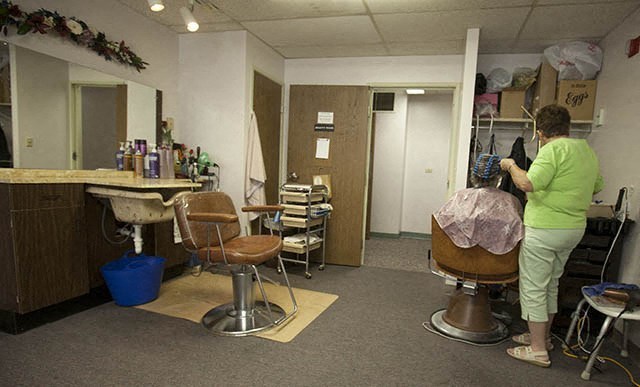 a woman in a barber shop getting her hair cut