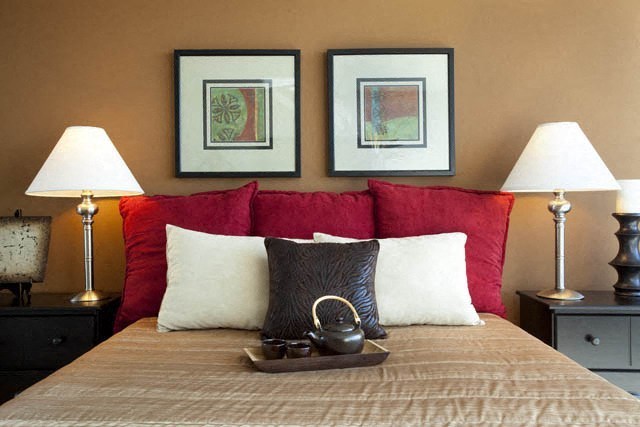 a bedroom with a bed with three pictures on the wall