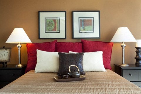 a bedroom with a bed with three pictures on the wall