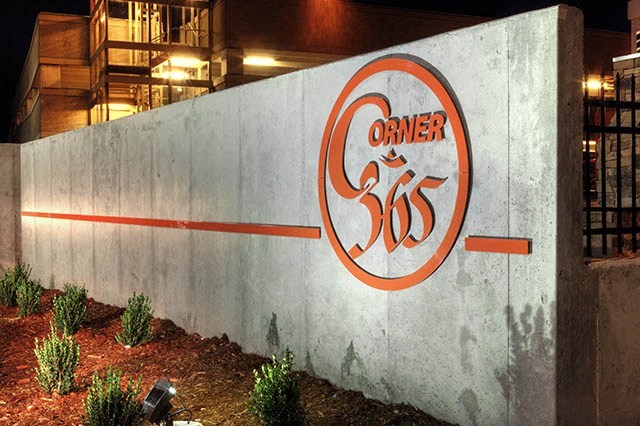 a sign on the side of a wall in front of a building