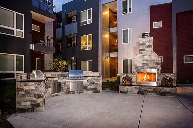 an outdoor area with a fireplace and an apartment building