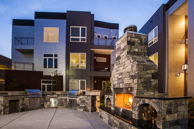 a building with an outdoor fireplace in front of it