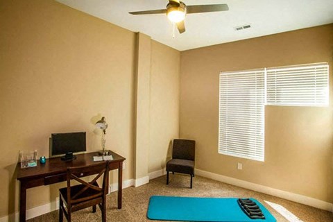 a room with a desk and a yoga mat
