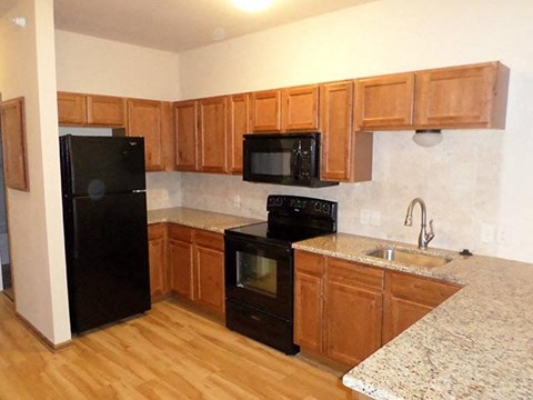 a kitchen with black appliances and wooden cabinets