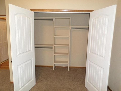 an empty closet with shelves and a ladder