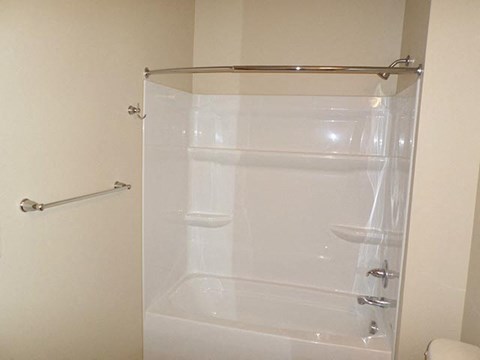a white bathroom with a shower and a toilet