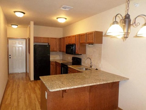 a kitchen with a granite counter top and a black refrigerator