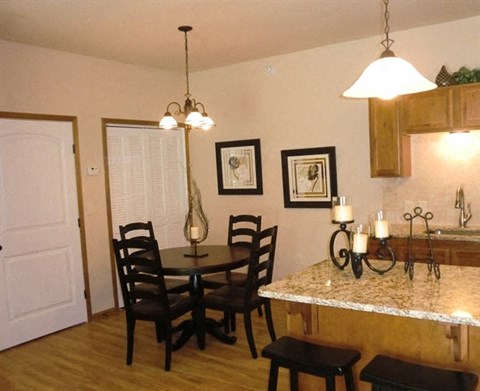 a dining room and kitchen with a table and chairs