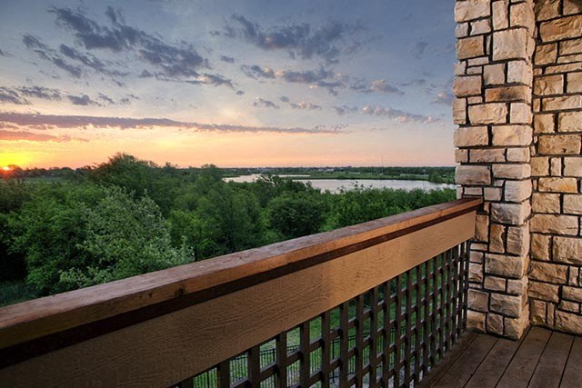 a balcony with a view of a river at sunset